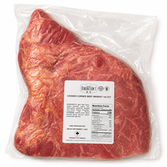 Packaged cooked kosher corned beef brisket with a label on a white background